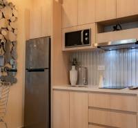 A kitchen corner in a 2-room apartment with wooden cabinets and a decorative mirror.