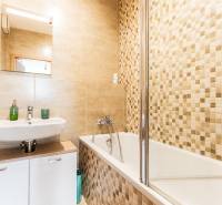 A bathroom with a shower and a sink in a 3-room apartment, tiled.