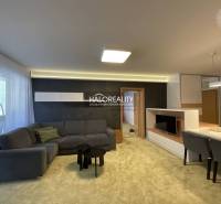 Living room in a 3-room apartment with a grey sofa and a television.