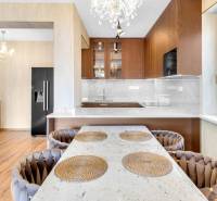 A kitchen in a 3-room apartment with a dining table, wooden floor, and a large window.