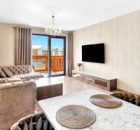 Living room in a 3-room apartment with a comfortable sofa, television, and large windows.