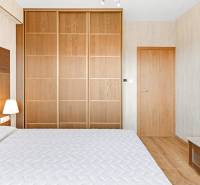 Bedroom with a double bed and a wooden wardrobe in a 3-room apartment.