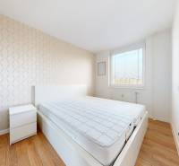 Bright bedroom in a 3-room apartment with a double bed, nightstand, and wooden floor.