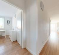 Hallway and office in a 3-room apartment with wooden flooring and white walls.