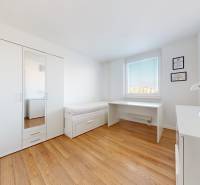 A bright room with a bed, wardrobe, desk, and lamp in a 3-room apartment.
