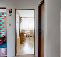 A hallway in a family house with three rooms and colored glass blocks.