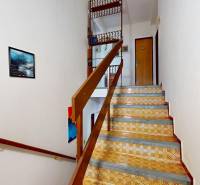 A staircase with a wooden railing and patterned steps in a family house.