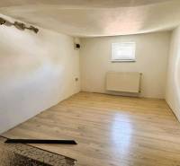 A room in a family house with laminate flooring and white walls.