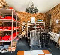 Brick walls of the room with shelves, metal products, and red boxes in the family house.