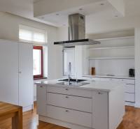 A kitchen in a 4-room apartment with an island, wooden flooring, and built-in appliances.