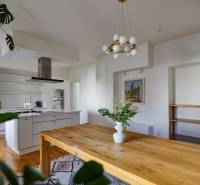 The kitchen of a 4-room apartment with a wooden table, a chandelier, and a decorative vase.