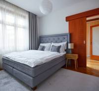 Bedroom in a 4-room apartment with a bed, nightstand, and wooden door.