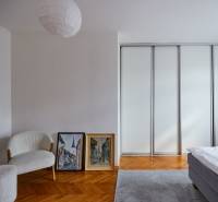 Bright bedroom with a wardrobe, armchair, and paintings in a 4-room apartment.