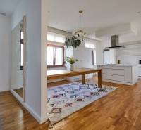 Interior of a 4-room apartment with wooden flooring, kitchen, and dining table.