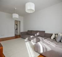 Living room with a large gray sofa and white lights in a 4-room apartment.