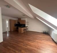 Attic kitchen and living room with wooden flooring in a 3-room apartment.