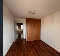 A room with a wooden floor and a built-in wardrobe in a 3-room apartment.