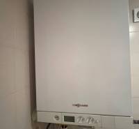 Gas boiler in the bathroom of a 3-room apartment with white tiles.