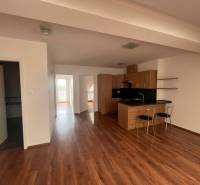Kitchen with dining area, wooden floors, bright walls, 3-room apartment.
