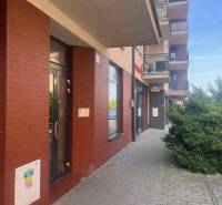 The exterior of a building in Dunajská Streda with a red brick facade and entrance doors.