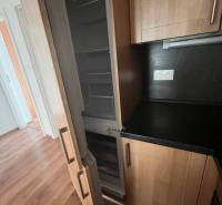 A kitchen in a 3-room apartment with a wooden floor and a built-in refrigerator.