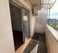 A balcony of a 3-room apartment with a view of the surroundings, glass doors, air conditioning.