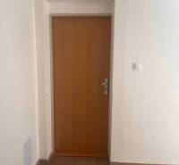 White walls and wooden doors in a 3-room apartment, light tiles on the floor.