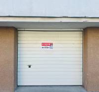 White garage door on Štefánik Square in Spišská Nová Ves with the sign for sale.