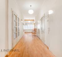 A long hallway with light wooden flooring in a family house.