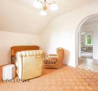 A comfortable living room in a family house with a retro sofa set and wooden flooring.