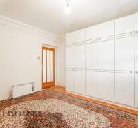 A room in a family house with a white wardrobe and a carpet.