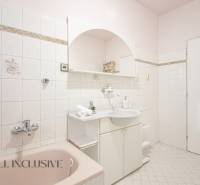 A bathroom in a family house with white tiles and light furniture.