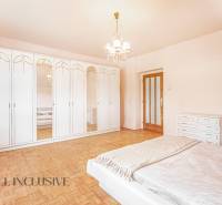 The master bedroom in the family house is adorned with spacious mirrored wardrobes and simple lighting.