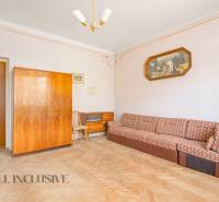 Living room in a family house with a sofa, wooden cabinet, and a painting.