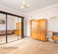 An interior with wooden furniture, a mirrored wardrobe, and a sofa in a family house.