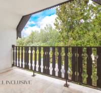 A balcony of a family house in Žihárec with a view of greenery and blue sky.