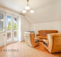 Living room with brown furniture, a sofa, and a French window in a family house.