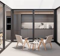 Interior of a family house with a kitchen, dining area, and a relaxation space with chairs.
