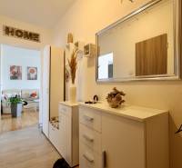 Entrance hall to a 2-room apartment with furniture and a mirror, at the entrance to the living room.