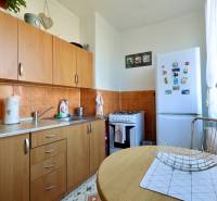 Kitchen in a 2-room apartment with wooden cabinets, appliances, and decorations.