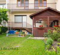 A family house in Dunajská Streda with a wooden veranda, garden, and balconies.