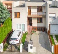 A family house in Dunajská Streda with a car parked on the driveway in front of the garden.