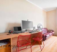 A desk with red chairs and a computer in a family house.