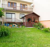 A family house in Dunajská Streda with a garden and a gazebo, surrounded by greenery and flowers.