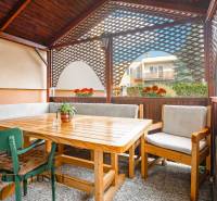 The terrace of a family house in Dunajská Streda with wooden seating and flowers.