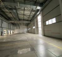 A spacious interior with skylights and a concrete floor in a warehouse and hall.