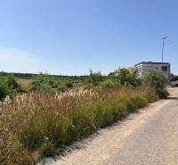 Land - housing in Cabaj-Čápor, road, greenery, and building on the edge of the forest.
