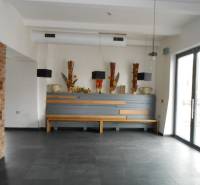 Interior of commercial spaces with decorative vases and a large window on the right side.