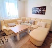 A corner sofa with cushions and a coffee table in the living room of a family house.