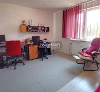 A study in a family house with computers, office chairs, and a window with vertical blinds.